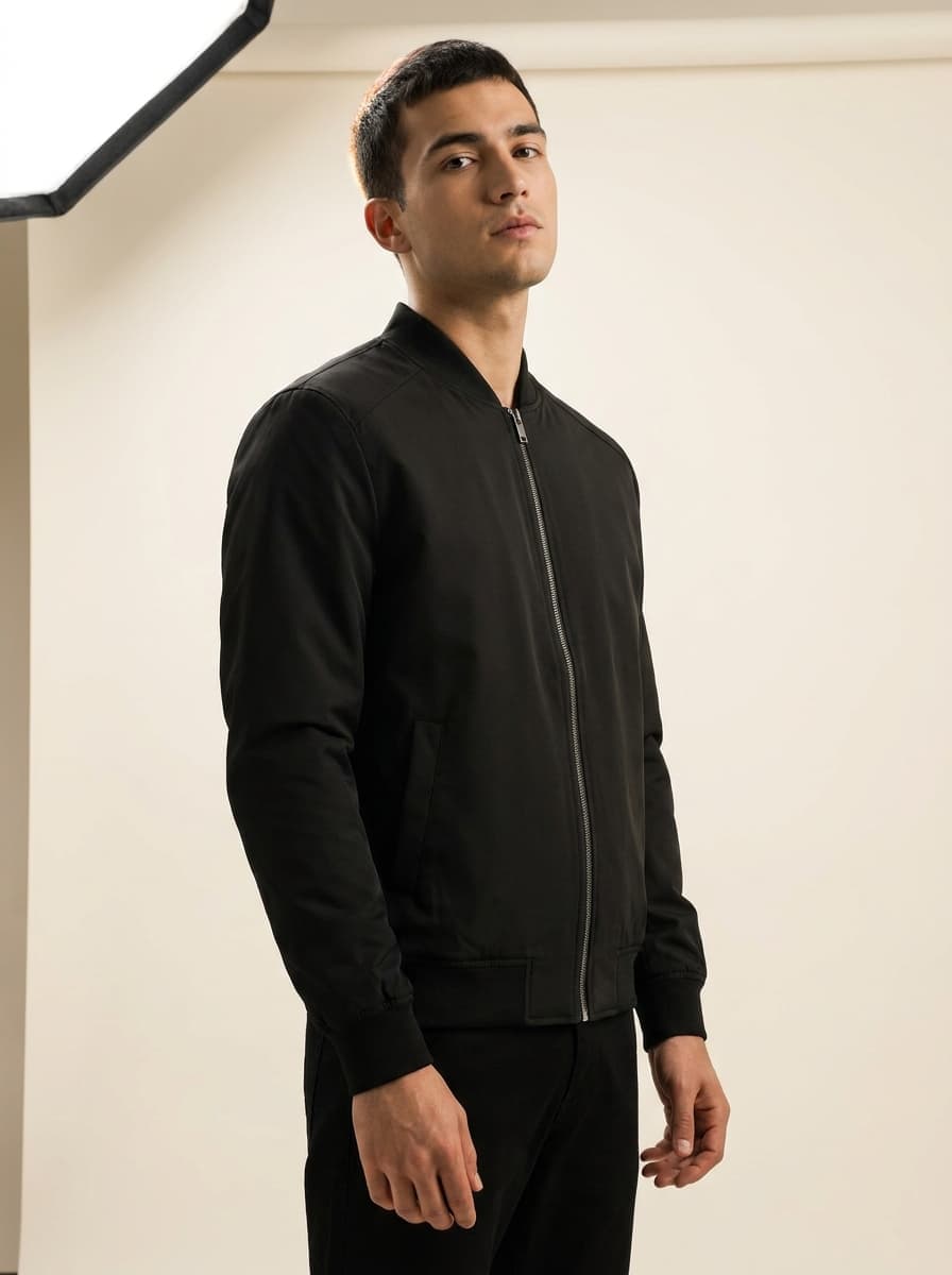 A model wearing a black bomber jacket in a clean studio shot, the kind of product page voice can open in seconds